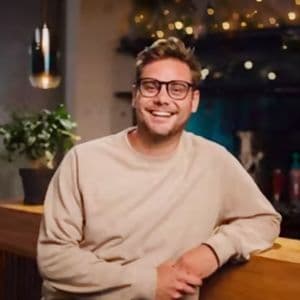 Patric Bökemeyer, COO von Kapten & Son, lehnt sich an einen Hochtisch